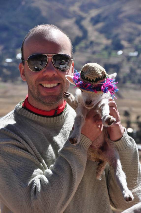 O Gustavo segura um fillhote de lhama no Valle Sagrado, nas proximidades de Cusco, no Peru